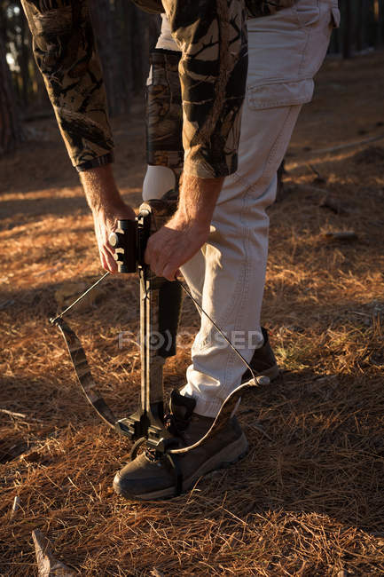 Jäger justiert Pfeil und Bogen an einem sonnigen Tag im Wald — Stockfoto