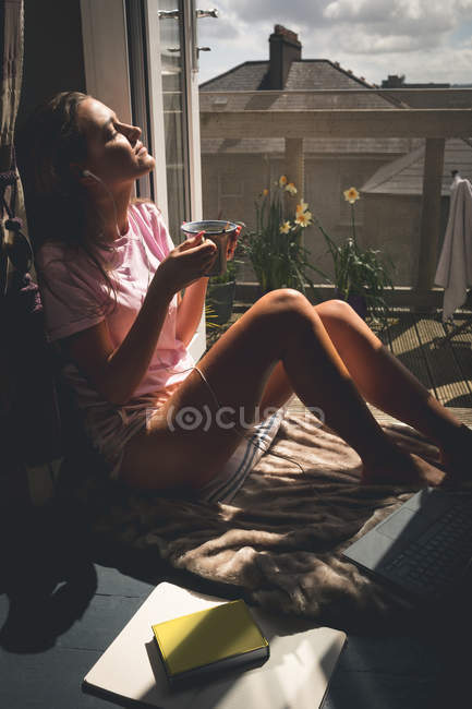 Женщина пьет черный кофе в гостиной дома — стоковое фото