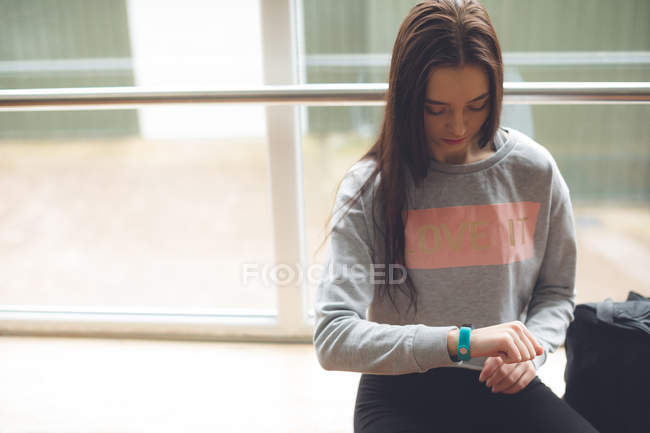 Female dancer checking time on her smartwatch in dance studio — Stock Photo