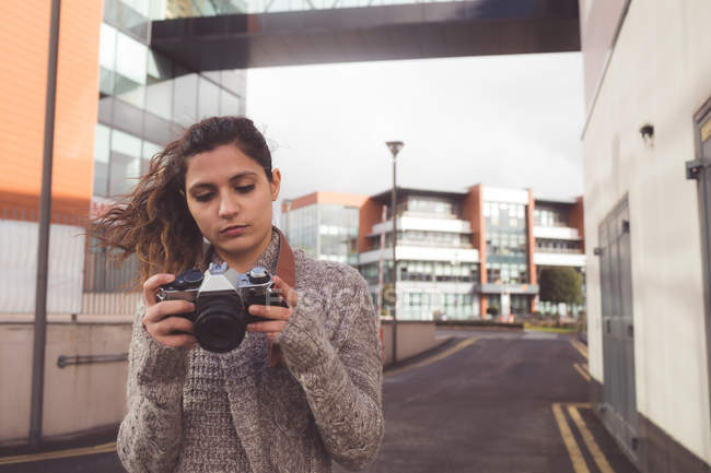 Woman reviewing photo with digital camera in the city — Stock Photo