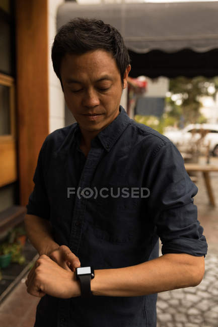 Homme d'affaires utilisant smartwatch dans le café — Photo de stock