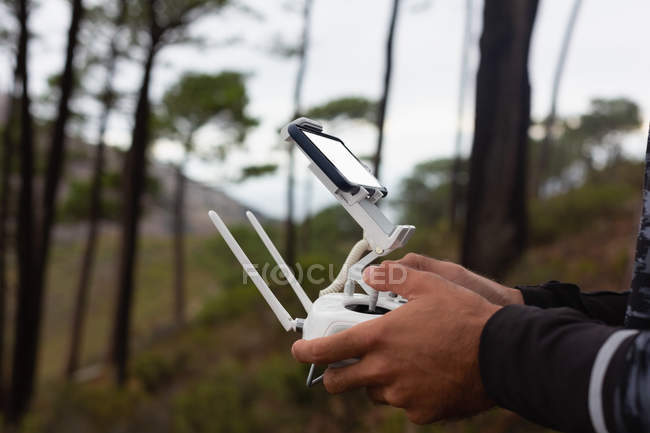 Sección media del hombre operando un dron volador - foto de stock