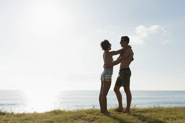 Pareja romántica de pie juntos en la playa - foto de stock