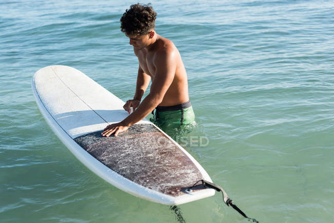 Surfista di sesso maschile che pratica surf con tavola da surf in mare in una giornata di sole — Foto stock