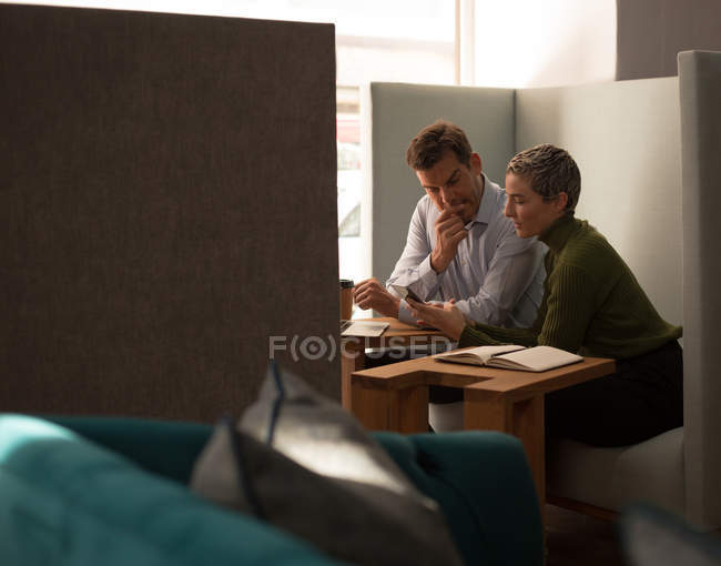 Деловые коллеги, взаимодействующие друг с другом в столовой на работе — стоковое фото
