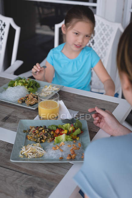 Мати і дочка їдять разом вдома — стокове фото