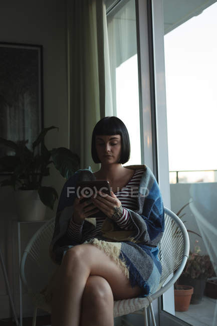 Jovem mulher usando tablet digital em casa — Fotografia de Stock