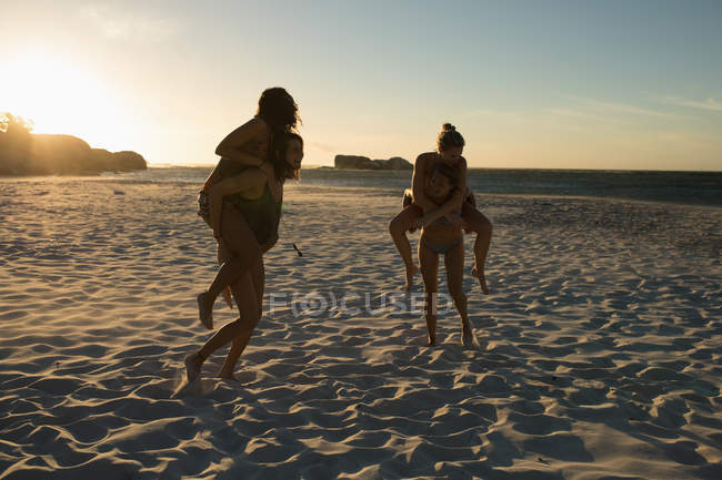 Жіночий Волейбол гравці веселяться на березі моря в сутінках — стокове фото