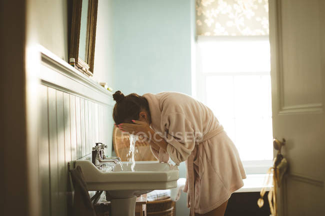 Жінка, миття її обличчя у ванній кімнаті в домашніх умовах — стокове фото