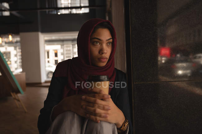 Femme d'affaires inquiète dans hijab détente à la cafétéria de bureau — Photo de stock