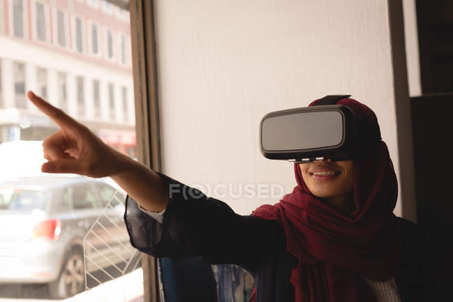 Бізнес-леді в хіджабі, використовуючи гарнітуру віртуальної реальності в офісних кафетеріях — стокове фото