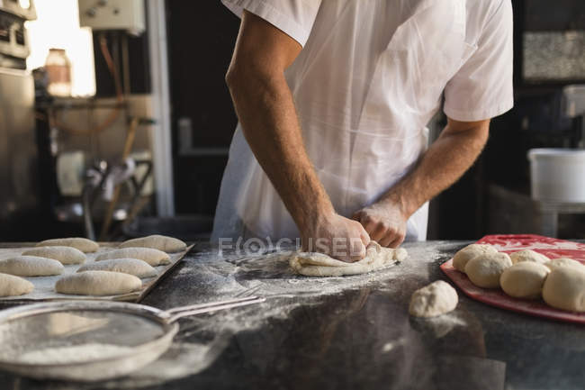 Seção média de padeiro macho preparando massa na padaria — Fotografia de Stock