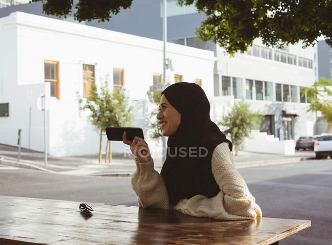 Bella donna hijab urbano parlando sul telefono cellulare al caffè marciapiede — Foto stock