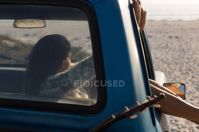 Mulher relaxante em uma caminhonete na praia — Fotografia de Stock