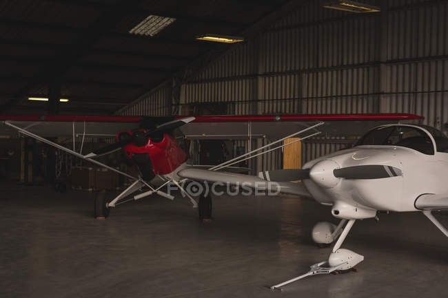 Two manufactured aircrafts parked in aerospace hangar — Stock Photo
