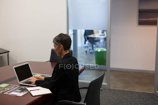Femme d'affaires utilisant ordinateur portable au bureau dans le bureau — Photo de stock