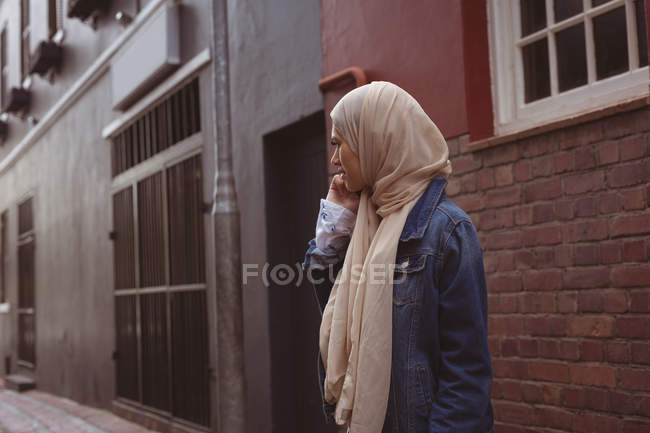 Красива хіджаб жінка розмовляє на мобільному телефоні на алеї — стокове фото