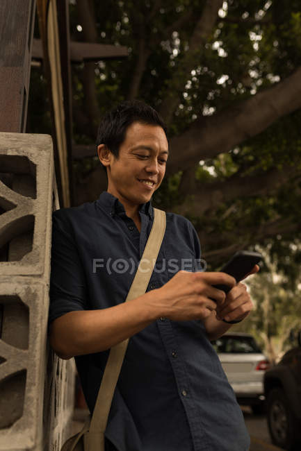 Улыбающийся бизнесмен с помощью мобильного телефона — стоковое фото