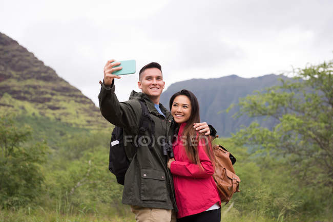 Happy couple prenant selfie avec téléphone portable dans la campagne — Photo de stock