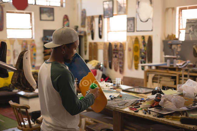 Man making skateboard in workshop — Stock Photo