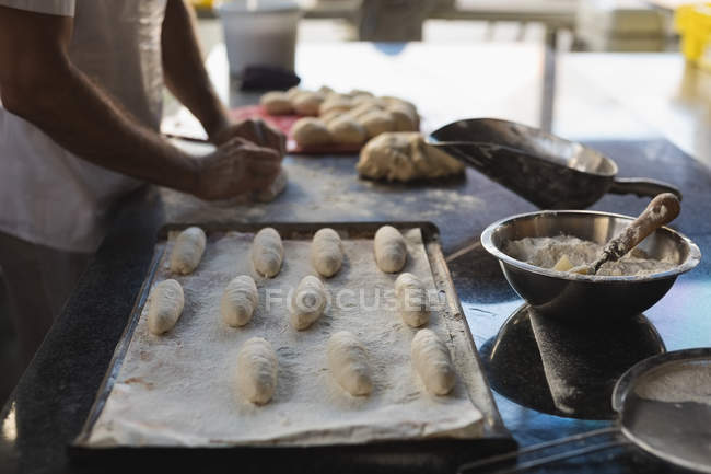 Section médiane du boulanger masculin préparant la pâte dans la boulangerie — Photo de stock