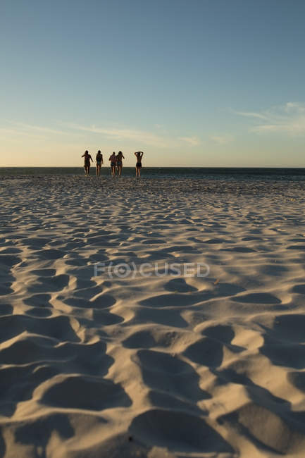 Female volleyball players running together on the beach — Stock Photo