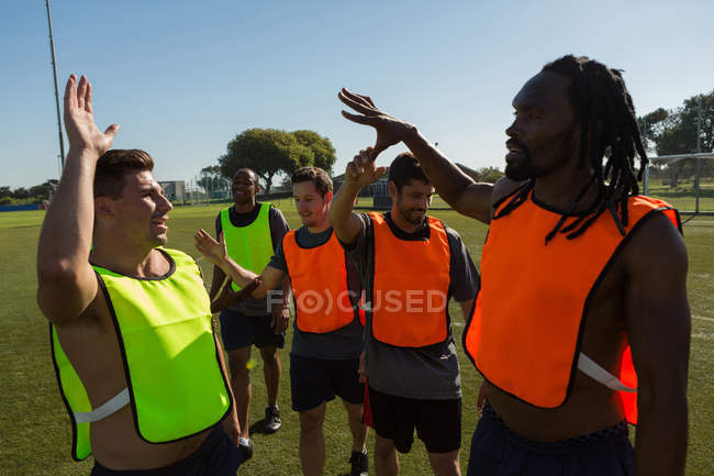 Players giving high five to each other in the field — Stock Photo