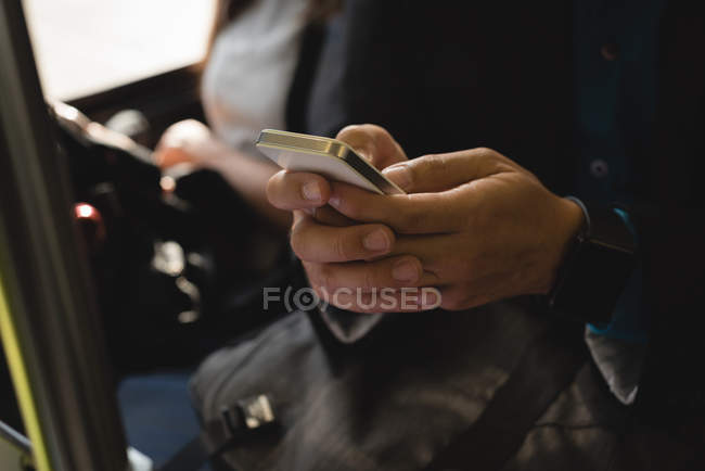 Mid section of businessman using mobile phone in bus — Stock Photo