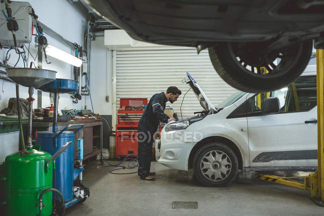Mécanicien masculin entretien de voiture au garage de réparation — Photo de stock