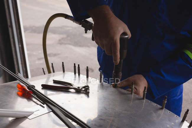 Engineer tightening screw on airplane parts in aerospace hangar — Stock Photo