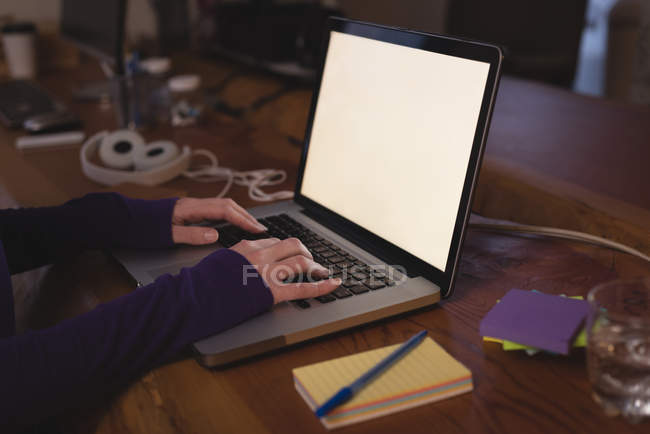 Жіночий керівник використовує ноутбук за столом в офісі — стокове фото