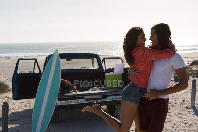 Coppia che si abbraccia in spiaggia in una giornata di sole — Foto stock