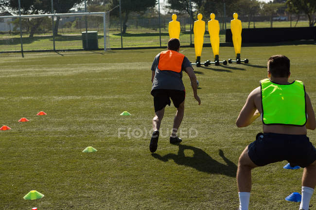 Visão traseira de jogadores de futebol praticando no campo — Fotografia de Stock