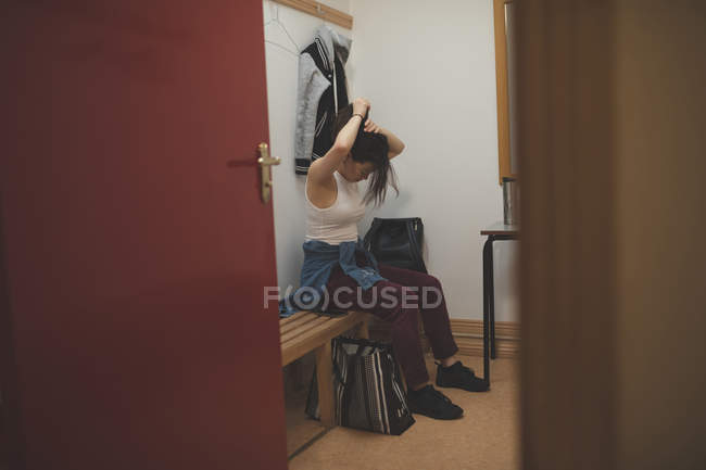 Female dancer tying her hairs in changing room at dance studio — Stock Photo