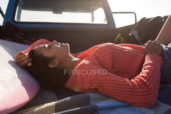 Jeune femme dormant dans une camionnette à la plage — Photo de stock