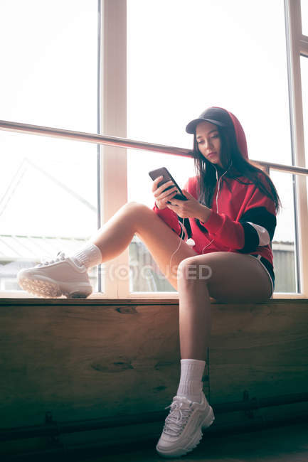 Jeune danseuse utilisant un téléphone portable dans un studio de danse — Photo de stock