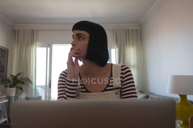 Mujer pensativa relajándose en casa - foto de stock
