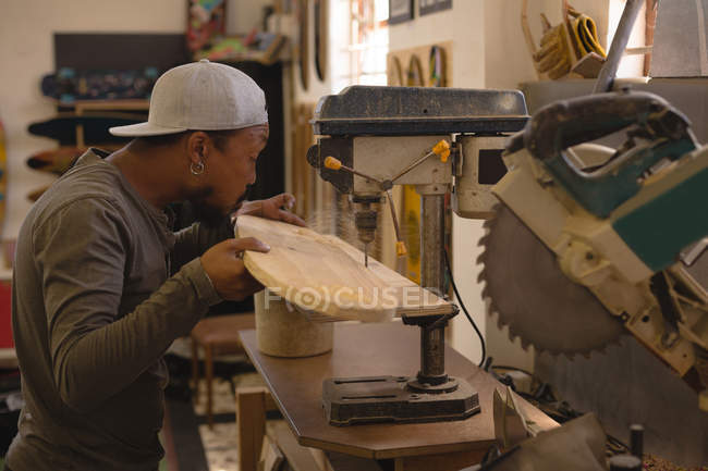 Человек с помощью радиальной буровой машины в мастерской — стоковое фото