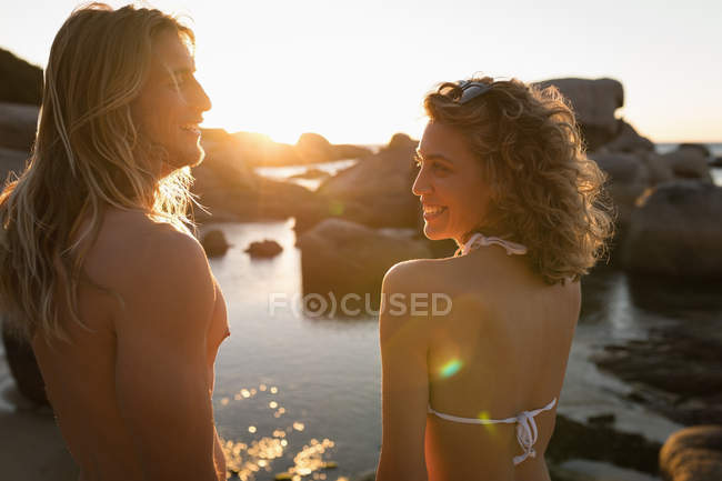 Casal se divertindo na praia ao entardecer — Fotografia de Stock