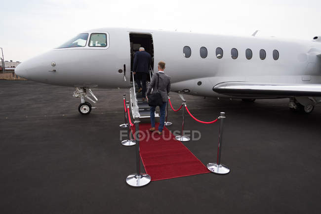 Business people boarding in private jet at terminal — Stock Photo