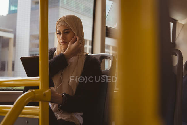 Mulher hijab bonita usando tablet digital no ônibus — Fotografia de Stock