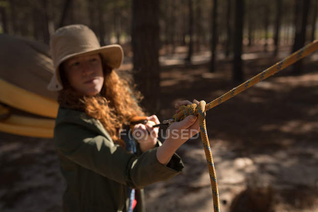 Donna che regola la cinghia del hammock all'albero nella foresta — Foto stock