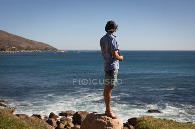 Вид сзади на человека, стоящего на пляже — стоковое фото