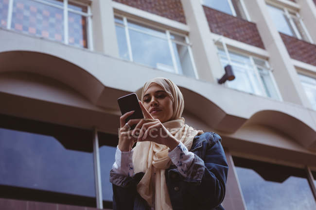 Vista a basso angolo di bella donna hijab utilizzando il telefono cellulare — Foto stock