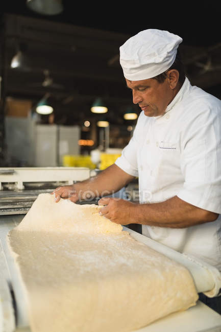 Maduro panadero masculino que trabaja en panadería - foto de stock