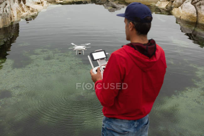 Uomo che aziona un drone volante in campagna — Foto stock