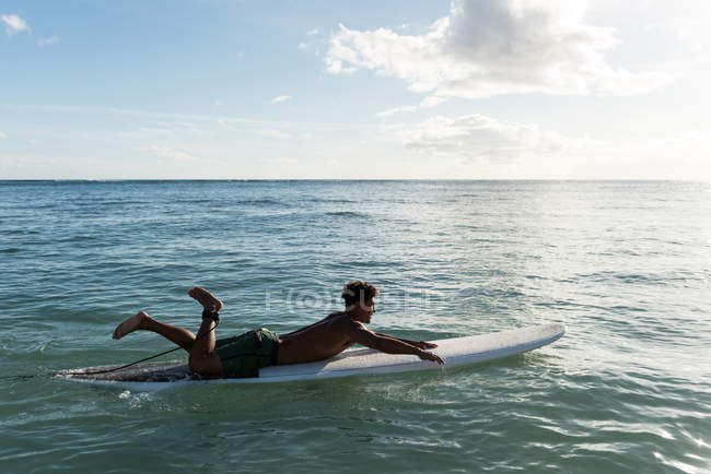 Мужской серфинг с доской для серфинга в море в солнечный день — стоковое фото