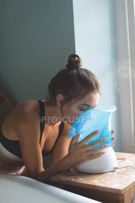 Frau nimmt Gesichtsdampf im Badezimmer zu Hause — Stockfoto