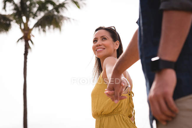Casal romântico acordando de mãos dadas perto da praia — Fotografia de Stock