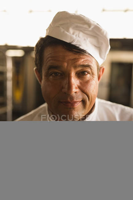 Портрет чоловічого пекаря, що стоїть у хлібопекарні — стокове фото